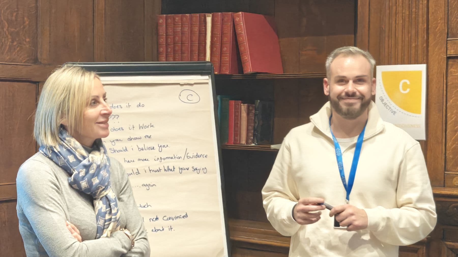 Two participants smiling beside a flip chart